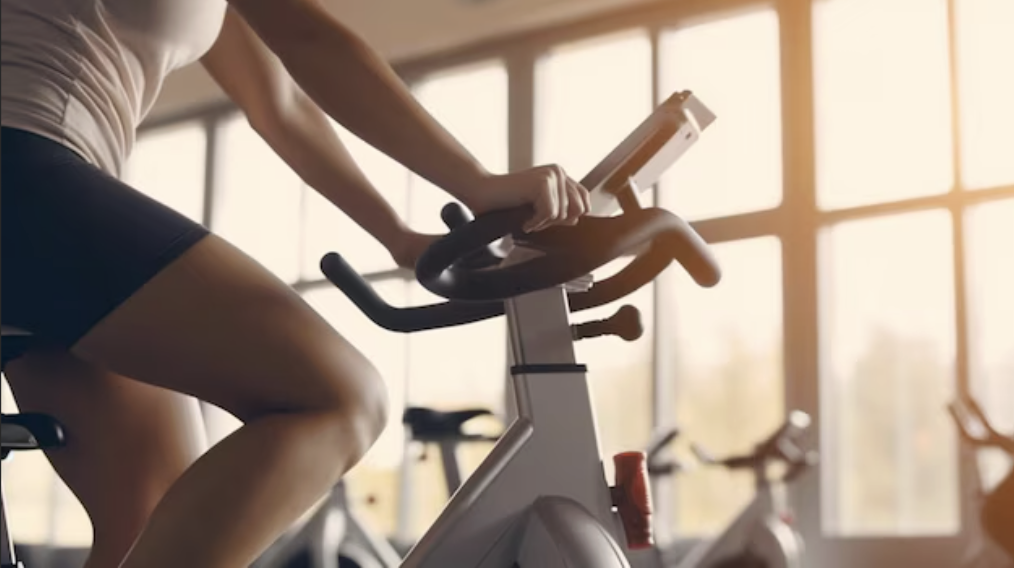 woman riding stationary exercise bike at gym